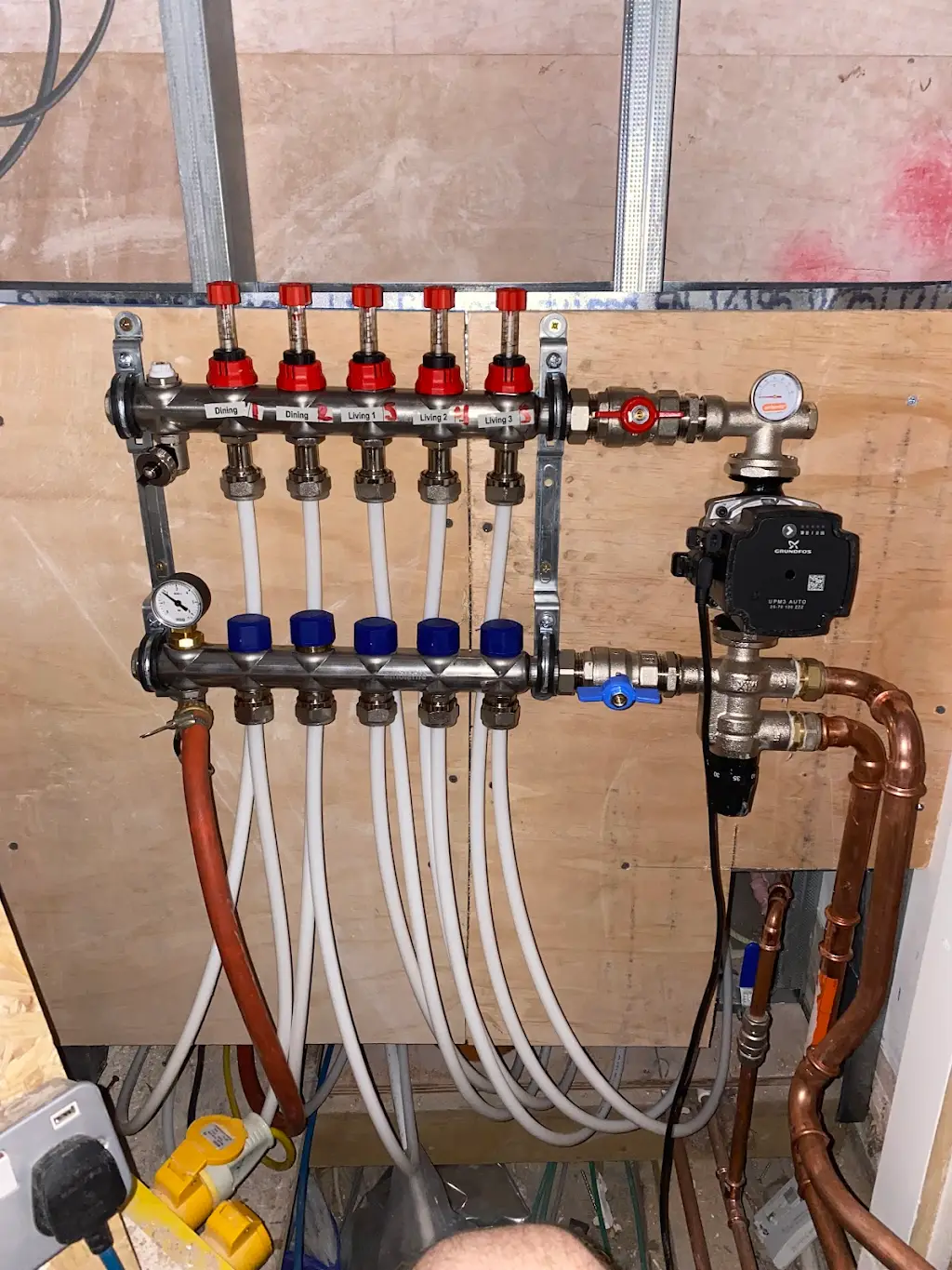 unnamed-57 Underfloor heating manifold with circulation pump, control valves and connected pipework.