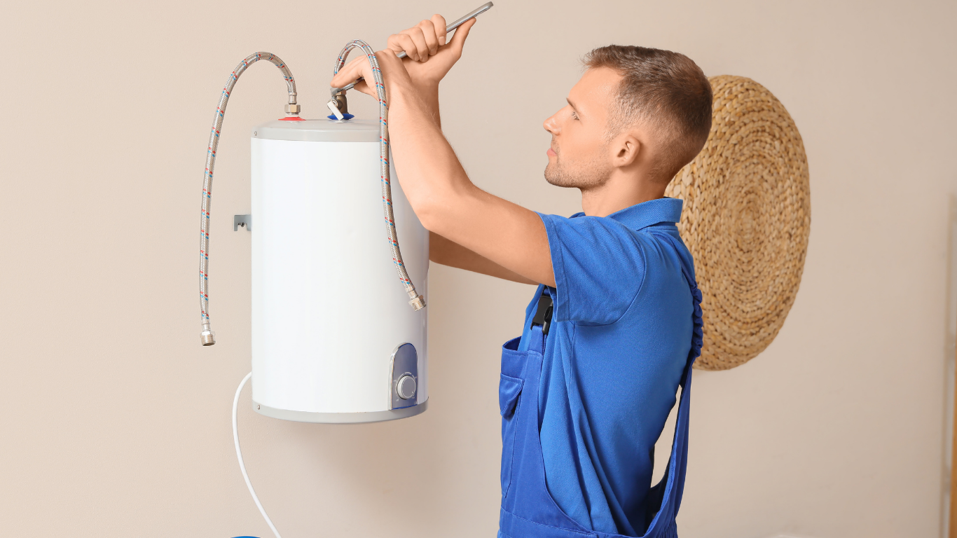 Plumber adjusting waste pipework beneath a double kitchen sink.